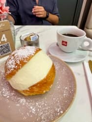 Ale Włosi są dobrzy w jedzenie, na zdjęciu Maritozzo - miękka, słodka bułka drożdżowa, wypełniona ogromną ilością świeżo ubitej śmietany (panna montata) #jedzzhejto śniady typ w tle to ja, także trochę #pokazmorde